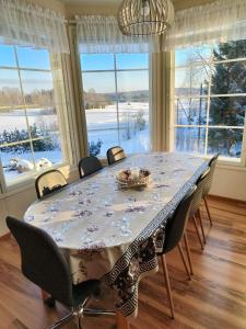 a dining room table with chairs and a large window at Huvila Lohja in Lohja