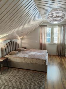 1 dormitorio con 1 cama grande y techo de madera en Huvila Lohja, en Lohja
