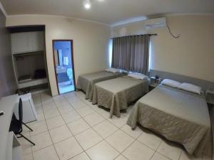 a hotel room with two beds and a mirror at Lito Palace Hotel in Registro +56 photos