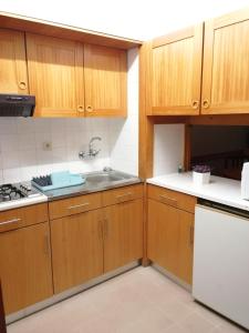 a kitchen with wooden cabinets and a sink at Charming apartment in São Pedro do Sul 30 m² with lake view in São Pedro do Sul