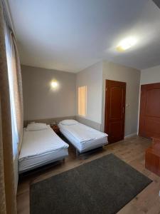 two beds in a small room with a room with at Hotel Arkadia in Końskie