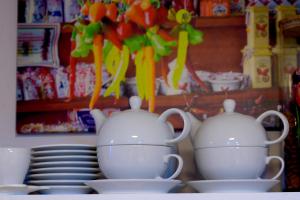 Dom Gościnny "Zawiśle" في فووتسوافيك: قدور شاي بيضاء وصحون فوق الأطباق