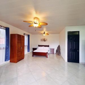- une chambre avec un lit et un ventilateur de plafond dans l'établissement Quinta El Molino, à San José