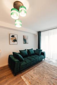 un divano verde in un soggiorno con finestra di VIVO Residence Short Stay a Baia Mare