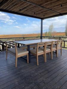 una mesa de picnic y sillas en una terraza de madera en Tupungato Winelands Casa de Piedra en Tupungato