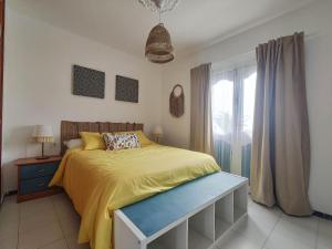 a bedroom with a yellow bed and a window at Casa SunRise in Punta Mujeres