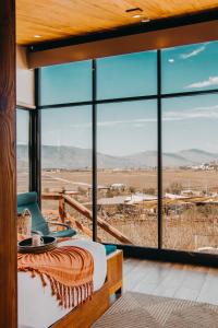 - une chambre avec un lit et une grande fenêtre dans l'établissement Contemplacion Resort & Spa, à Valle de Guadalupe