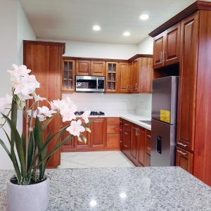 a kitchen with wooden cabinets and a vase with flowers at Quinta El Molino in San José