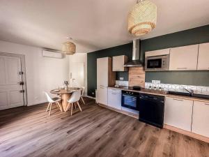 a kitchen with a table and a dining room at T2 Le Miredames in Castres