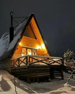 a log cabin in the snow at night at Vikendica Tromedja Pale in Pale