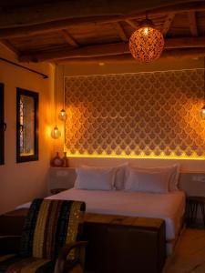 a bedroom with a bed and a wall with lights at Sahara pearl Hotel in Merzouga