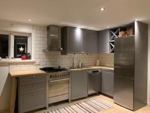 a kitchen with gray cabinets and stainless steel appliances at 1800 tals Sjötorp med egen strand och brygga in Åkersberga +47 photos