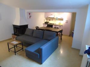 a living room with a blue couch and a kitchen at Hotel Rainbow in Arma di Taggia