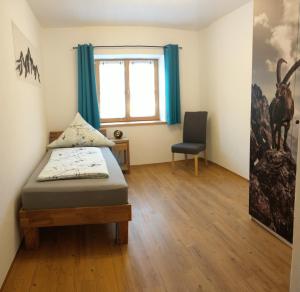 a bedroom with a bed and a chair in it at AlpStern Ferienwohnung in Oberstdorf