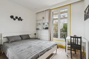 ein Schlafzimmer mit einem Bett und einem großen Fenster in der Unterkunft Unique Apartment for 4 - Paris & Disney in Champigny-sur-Marne