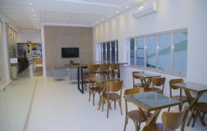 a dining room with tables and chairs and a tv at Lito Palace Hotel in Registro