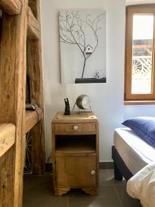 a bedroom with a bed and a nightstand with a lamp at Cocon à colombage alsacien "1789" in Innenheim