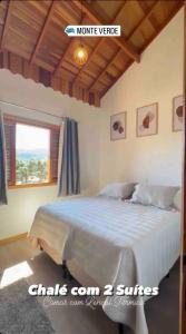 a bedroom with a large bed with a window at Chales Campestre Monte Verde - 150 mts do Centro in Monte Verde