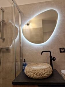 La salle de bains est pourvue d'un lavabo en pierre et d'un miroir. dans l'établissement Léman Holidays - Le Palm, à Mandelieu-la-Napoule