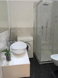 bagno con lavandino e doccia in vetro di Apartment Orio Volta a Orio al Serio