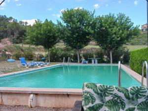 uma piscina num quintal com cadeiras e árvores em Belvilla by OYO Mas Set Rengs 2 em Guardiola