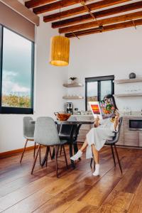 une femme assise à une table à manger pour lire un livre dans l'établissement Contemplacion Resort & Spa, à Valle de Guadalupe