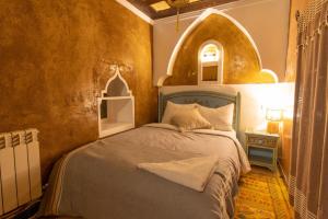 a bedroom with a bed in a room with an archway at Kasbah Assafar in El Kelaa des Mgouna