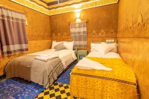 a room with two beds in a room at Kasbah Assafar in El Kelaa des Mgouna