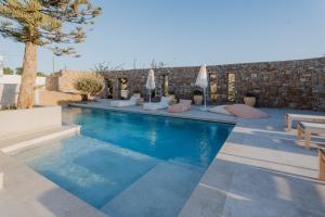 una piscina con acqua blu in una villa di Oliving Mykonos Luxury Suites a Klouvas