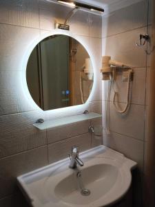 a bathroom with a sink and a mirror at Mairi`s apartments in Thessaloniki