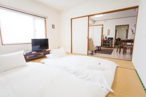 a bedroom with two beds and a large mirror at Yume House in Niseko