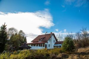 uma casa branca com um telhado castanho numa colina em Casa Pop em Câmpulung