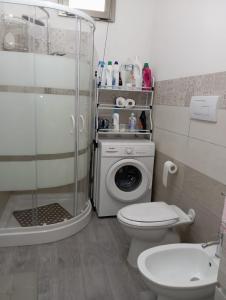 a bathroom with a shower and a toilet and a washing machine at Da Gianni in Pantelleria