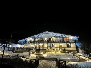 a large building at night with snow around it at Private House Scherbovets in Zhdenievo