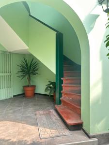 a staircase in a building with a green wall at Colonial Style Apartment in San Isidro in Lima