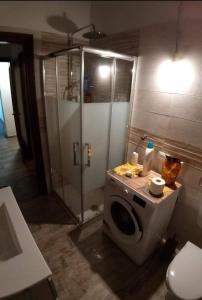 La salle de bains est pourvue d'une douche et d'un lave-linge. dans l'établissement Mansarda Natalia, à Gallio
