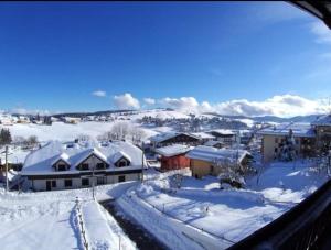 une ville couverte de neige avec des montagnes en arrière-plan dans l'établissement Mansarda Natalia, à Gallio