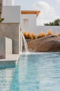 a swimming pool with a water fountain at Oliving Mykonos Luxury Suites in Klouvas
