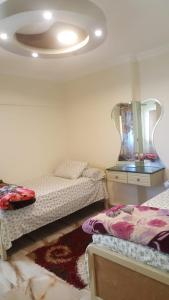 sypialnia z 2 łóżkami i sufitem w obiekcie City Square شقق فندقية مكيفة باطلالة علي البحر w Aleksandrii