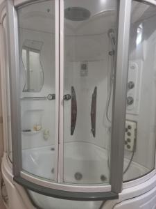 una ducha con una puerta de cristal con dos corbatas. en Đất Cảng Homestay en Hai Phong