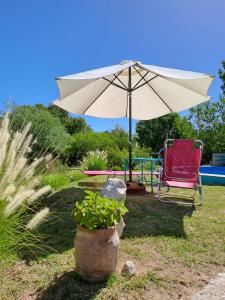 a chair and an umbrella and a chair and a table at Vayu- en La Casa de Nanda in San Javier