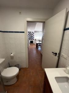 a bathroom with a toilet and a sink and a hallway at La casa de la avenida in Cenes de la Vega +18 photos