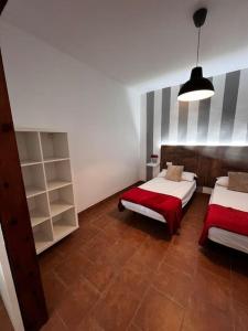 ein Schlafzimmer mit 2 Betten und einem Bücherregal in der Unterkunft La casa de la avenida in Cenes de la Vega