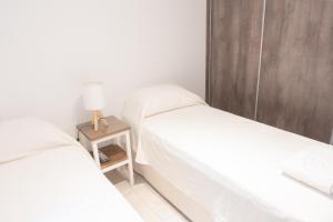 a bedroom with two beds and a night stand with a lamp at Torre Alem 4 A in San Miguel de Tucumán