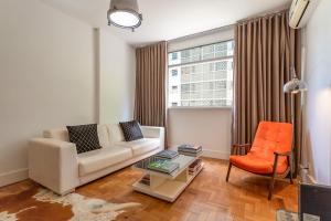 sala de estar con sofá y silla naranja en Unhotel - Apartamento Design no Leblon, Perto da Praia, en Río de Janeiro