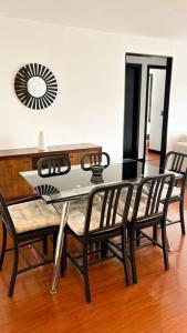 a dining room table and chairs with a table and a mirror at Departamento con vista panorámica in Quito