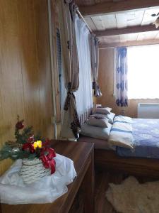 a room with two beds and a table with flowers on it at Dom Tatrzański Widok in Bustryk