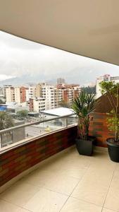 a balcony with potted plants and a view of a city at Departamento con vista panorámica in Quito