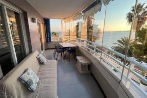 een balkon met een bank en uitzicht op de oceaan bij Apto Cala Real Playa Muchavista - ElCampello in Alicante