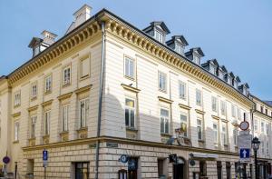 un grande edificio bianco all'angolo di una strada di Hotel Unicus Palace Old Town a Cracovia